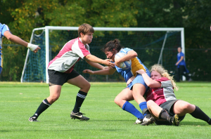 Andrea Portillo ’14 is tackled by two WPI players. The rugby team’s new coaches have been working with the players to improve their skills and tactics, including offensive moves like tackling.